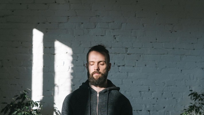 A person sitting in meditation in a naturally lit room